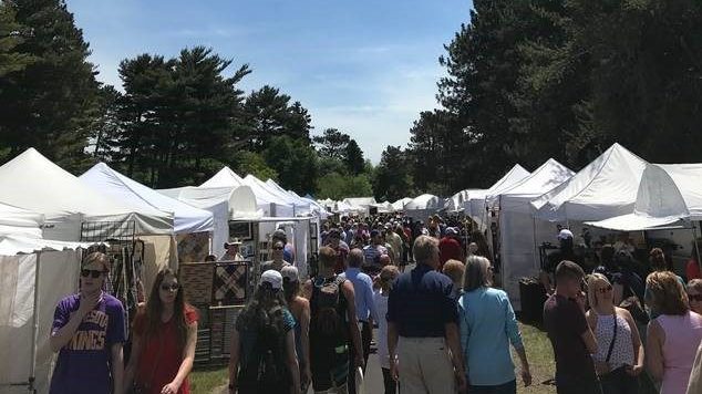 Park Point Art fair in Duluth with vendors in white tents lined up on each side white customers shop outside.